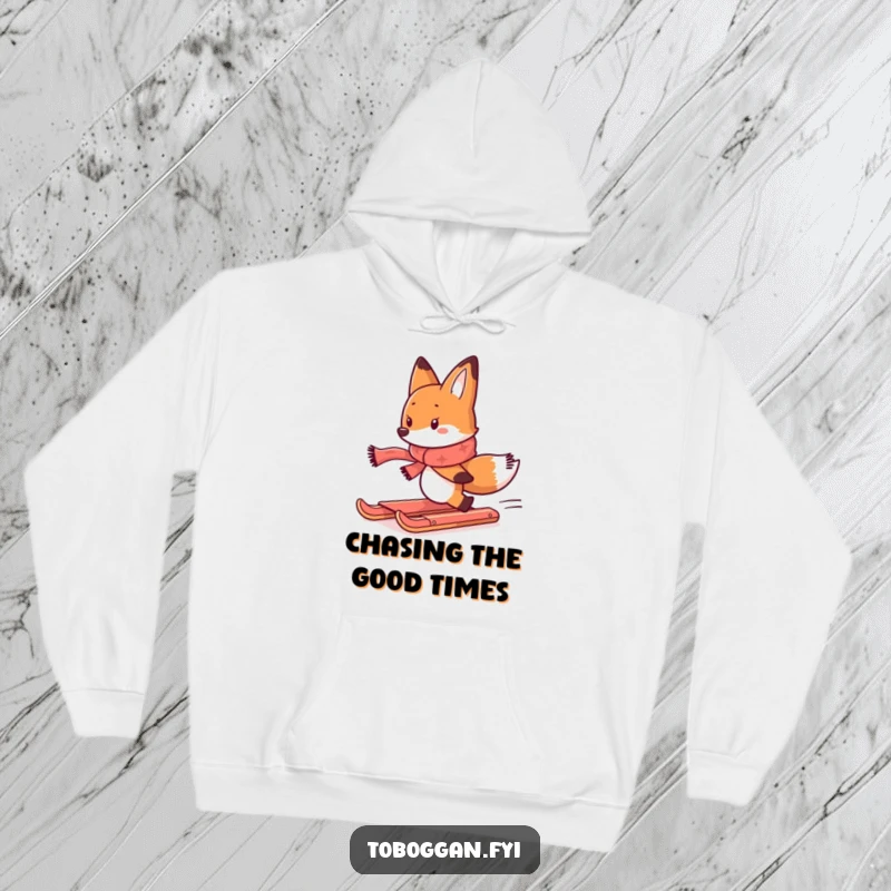 Funny hoodie showing a determined fox with a scarf chasing a runaway toboggan, ideal for cold weather laughs.