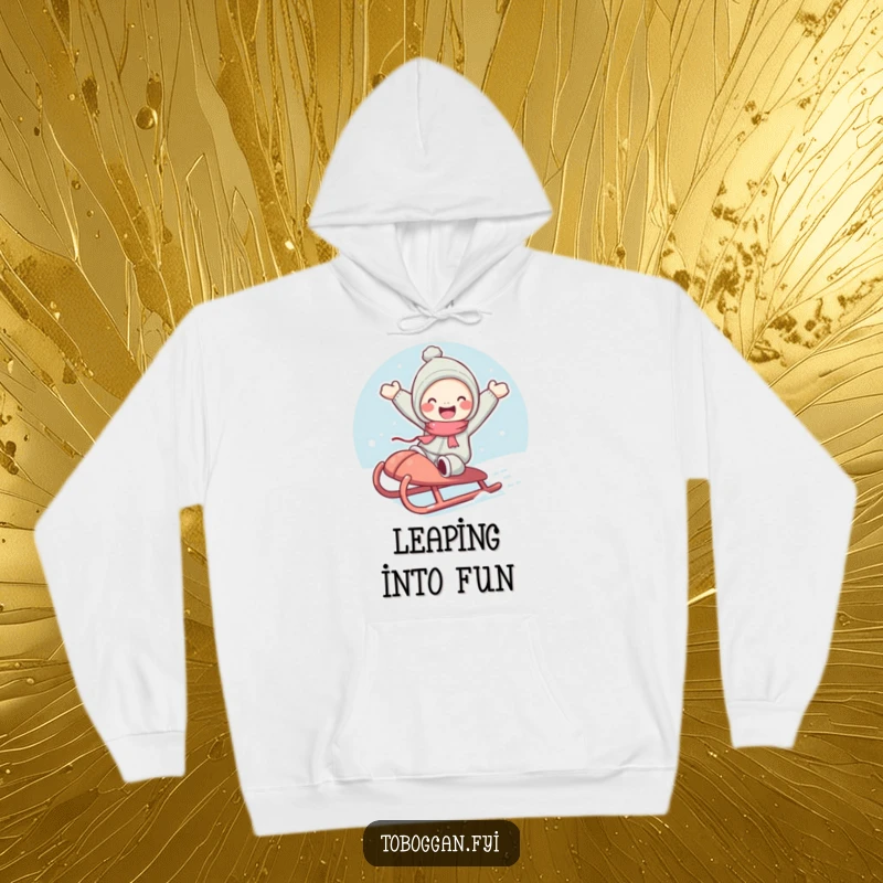 Funny hoodie showing a cute character with rosy cheeks joyfully jumping from a sled, perfect for cozying up.