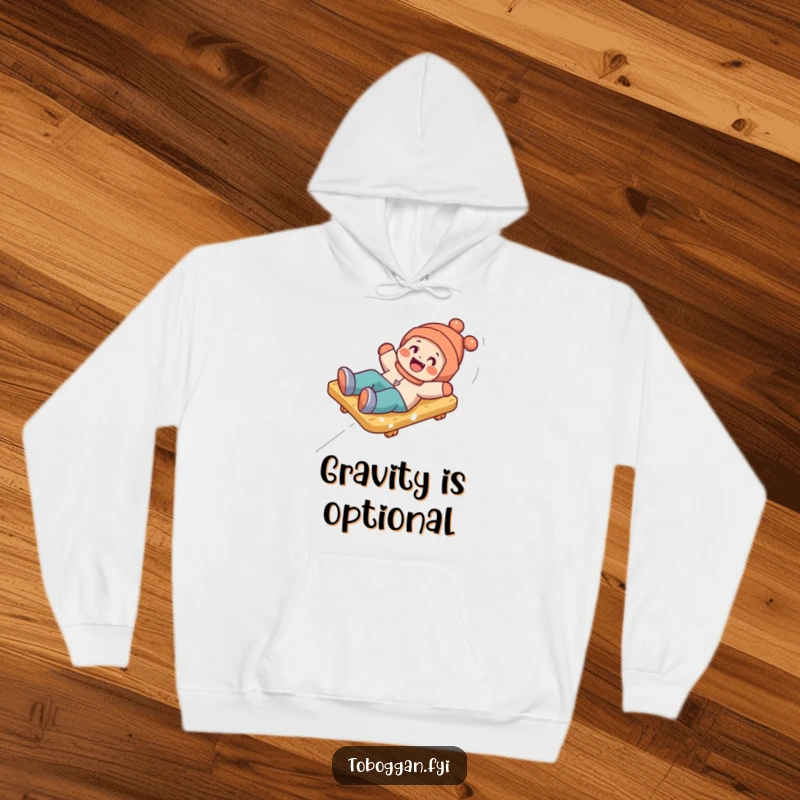 Funny hoodie showing a happy character playfully tumbling off a toboggan, perfect for cozying up with a laugh.