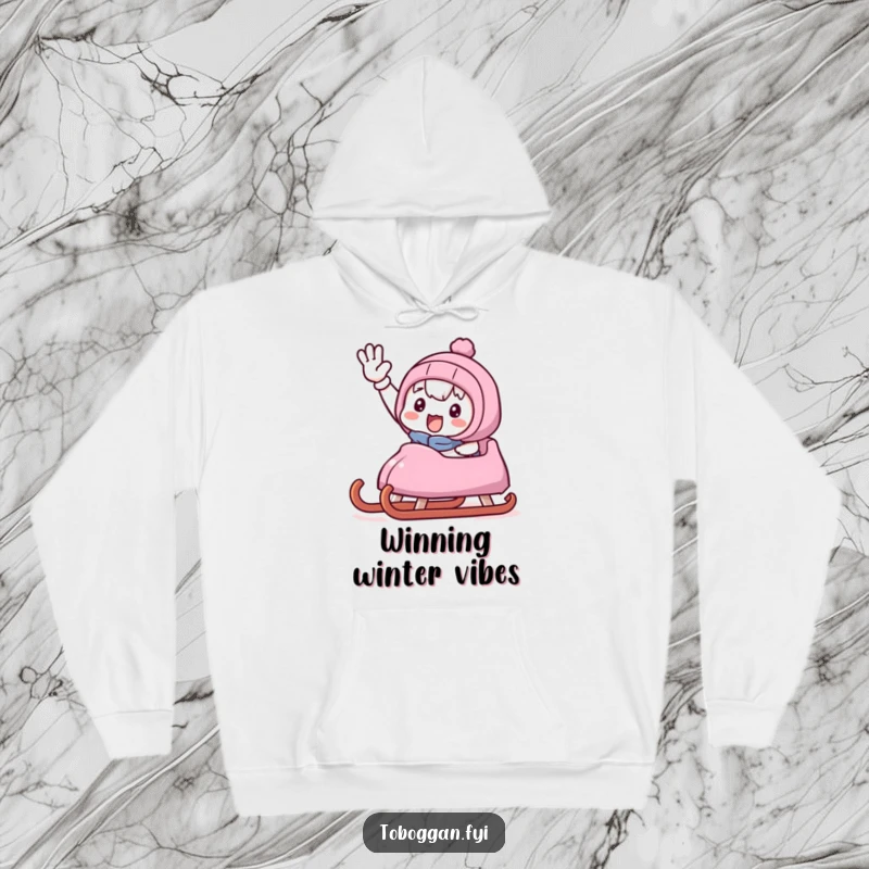 Funny hoodie showcasing a cute character giving a victorious wave from a sled, embodying pure winter fun and accomplishment.