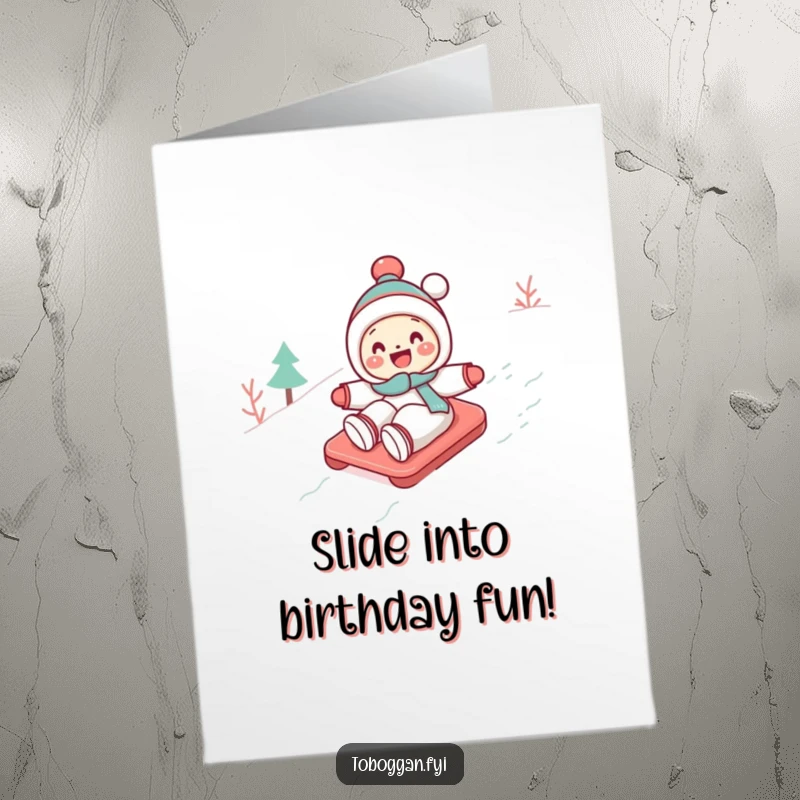 Funny Free Printable birthday card: a cute character gleefully tobogganing down a snowy slope with a joyful expression.