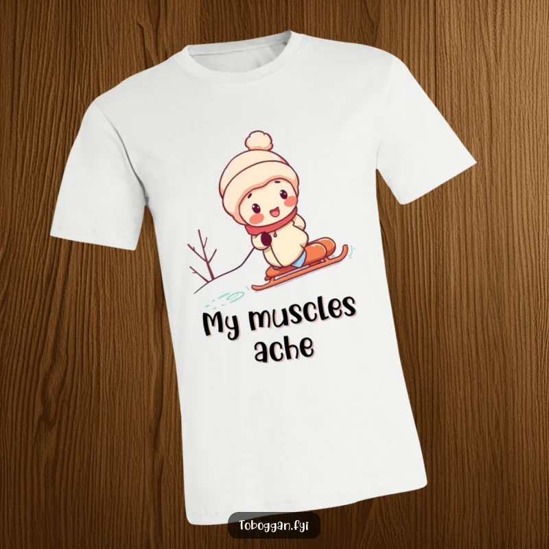 Funny t-shirt features a character with rosy cheeks, exerting maximum effort to push a sled up a steep, snowy incline, humorously depicting struggle.